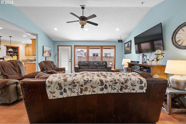 living room featuring lofted ceiling, ceiling fan, a textured ceiling, recessed lighting, and light wood-type flooring