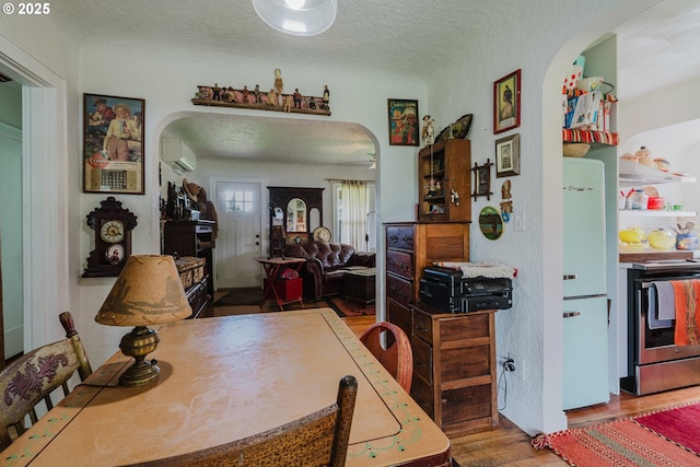 2112 Salem Ave, Albany, OR 97321 - dining room with arched walkways, an AC wall unit, wood finished floors, and a textured ceiling