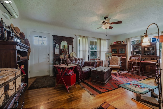 2112 Salem Ave, Albany, OR 97321 - living room featuring a wall unit AC, wood-type flooring, ceiling fan, and a textured ceiling