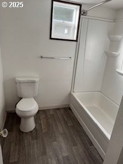 bathroom with a shower, wood finished floors, toilet, and baseboards