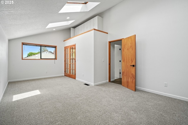 570 N Hayden Bay Dr, Portland, OR 97217 - empty room with a skylight, carpet floors, a textured ceiling, high vaulted ceiling, and baseboards