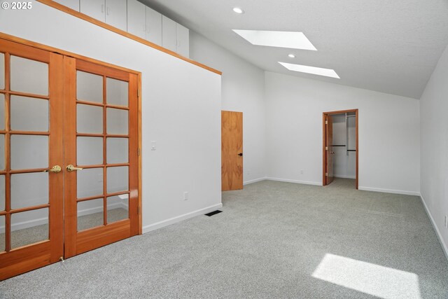570 N Hayden Bay Dr, Portland, OR 97217 - carpeted spare room with a skylight, vaulted ceiling, french doors, baseboards, and recessed lighting