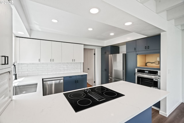 570 N Hayden Bay Dr, Portland, OR 97217 - kitchen featuring stainless steel appliances, recessed lighting, dark wood finished floors, a sink, and decorative backsplash