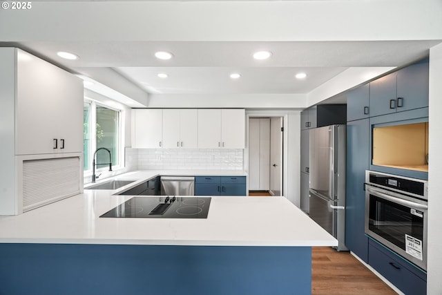 570 N Hayden Bay Dr, Portland, OR 97217 - kitchen with stainless steel appliances, a sink, recessed lighting, a peninsula, and light countertops