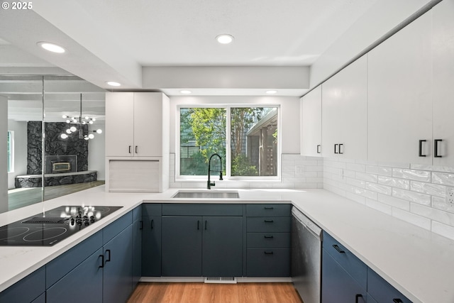 570 N Hayden Bay Dr, Portland, OR 97217 - kitchen with stainless steel dishwasher, black electric cooktop, a sink, tasteful backsplash, and recessed lighting