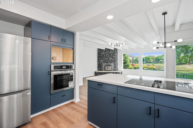 570 N Hayden Bay Dr, Portland, OR 97217 - kitchen with stainless steel appliances, blue cabinets, a chandelier, light wood-style floors, and beam ceiling