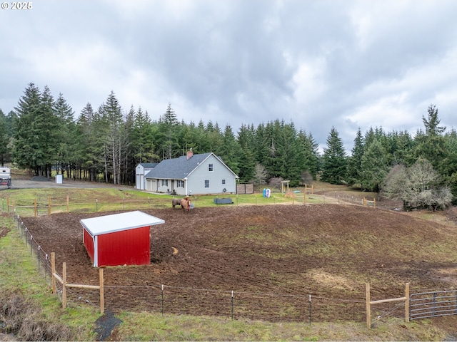 view of yard with an outbuilding, a rural view, and fence