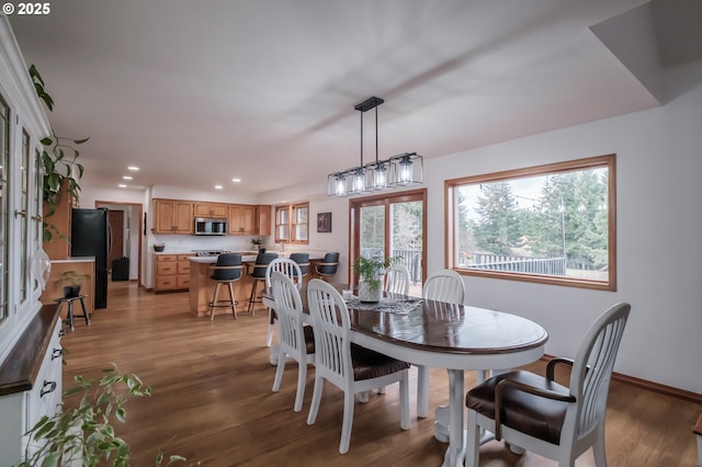 dining area with baseboards, wood finished floors, and recessed lighting