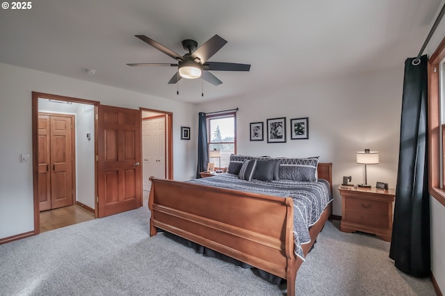 bedroom with light carpet, ceiling fan, and baseboards