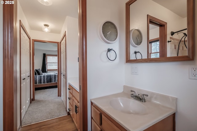 full bath featuring vanity, wood finished floors, and ensuite bathroom