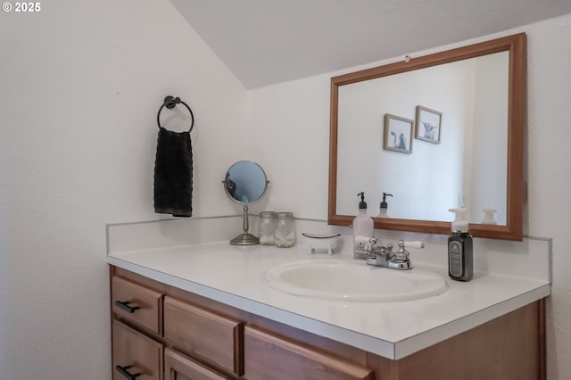 bathroom featuring lofted ceiling and vanity