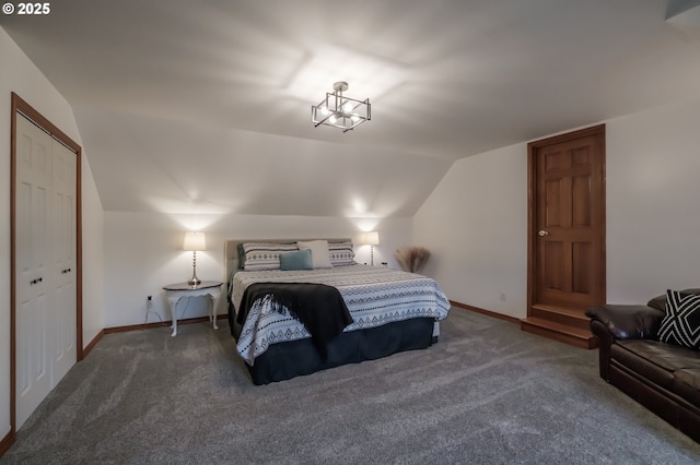 bedroom featuring lofted ceiling, dark carpet, and baseboards