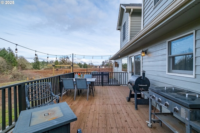 wooden deck featuring outdoor dining area and a grill