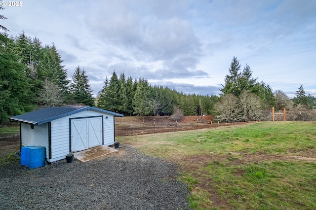 view of yard with a storage shed, an outdoor structure, and fence