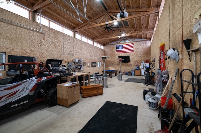 miscellaneous room with high vaulted ceiling and a workshop area