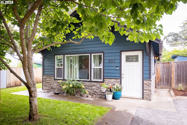 207 N Maple St, Bingen, WA 98605 - view of front of home with fence, a front lawn, and stone siding