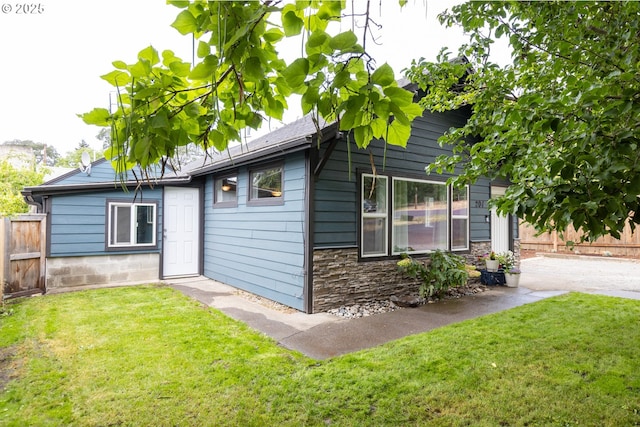 207 N Maple St, Bingen, WA 98605 - rear view of house with a lawn, fence, and stone siding