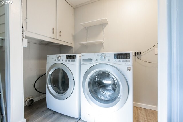 207 N Maple St, Bingen, WA 98605 - clothes washing area featuring baseboards, light wood-style flooring, cabinet space, and independent washer and dryer