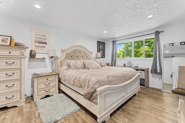 22165 SE Mark Rd, Damascus, OR 97089 - bedroom with light wood finished floors, a textured ceiling, and recessed lighting