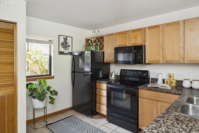 kitchen featuring black appliances, light tile patterned flooring, dark countertops, a sink, and baseboards