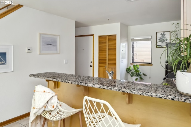 kitchen with stone counters and baseboards