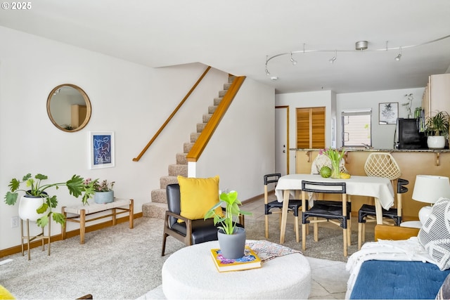 living area featuring stairs and baseboards