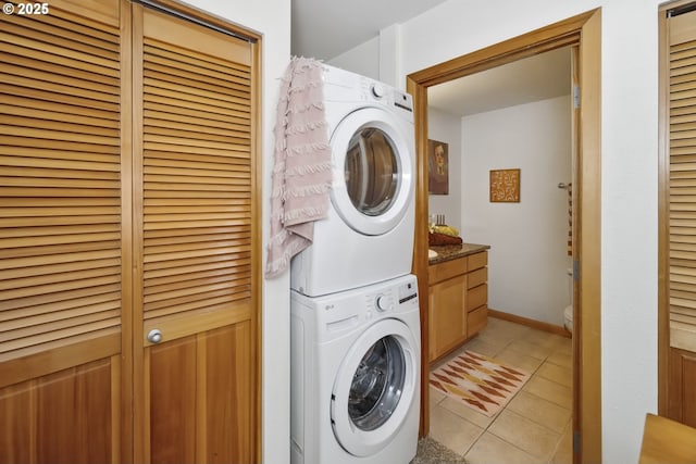 washroom featuring stacked washer and clothes dryer and light tile patterned floors