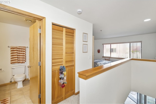corridor with baseboards, recessed lighting, and light tile patterned floors