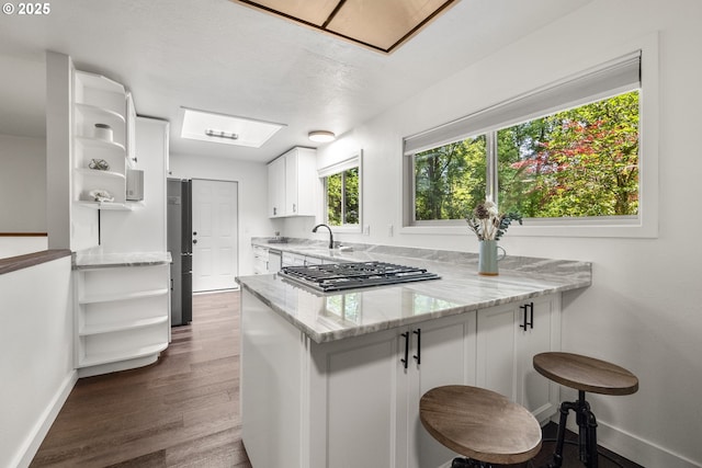 19065 Trillium Dr, West Linn, OR 97068 - kitchen with open shelves, a peninsula, baseboards, and light stone countertops