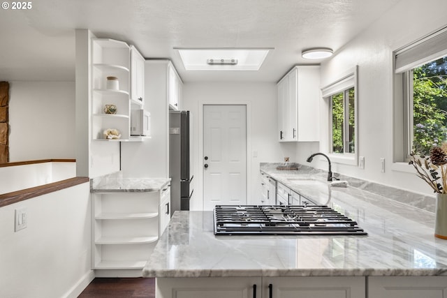 19065 Trillium Dr, West Linn, OR 97068 - kitchen featuring open shelves, stainless steel appliances, a sink, light stone counters, and white cabinets
