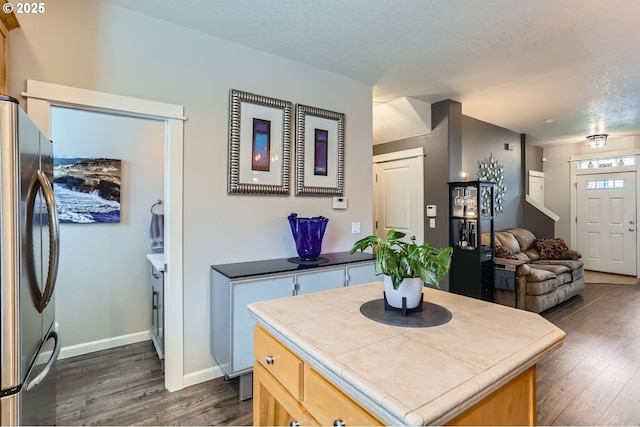 16070 SW Mason Ln, Beaverton, OR 97006 - kitchen featuring tile counters, freestanding refrigerator, dark wood finished floors, open floor plan, and baseboards