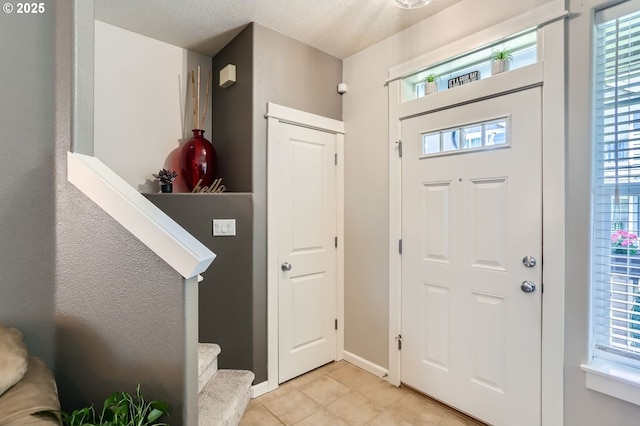 16070 SW Mason Ln, Beaverton, OR 97006 - foyer featuring light tile patterned flooring, a textured ceiling, stairway, and baseboards