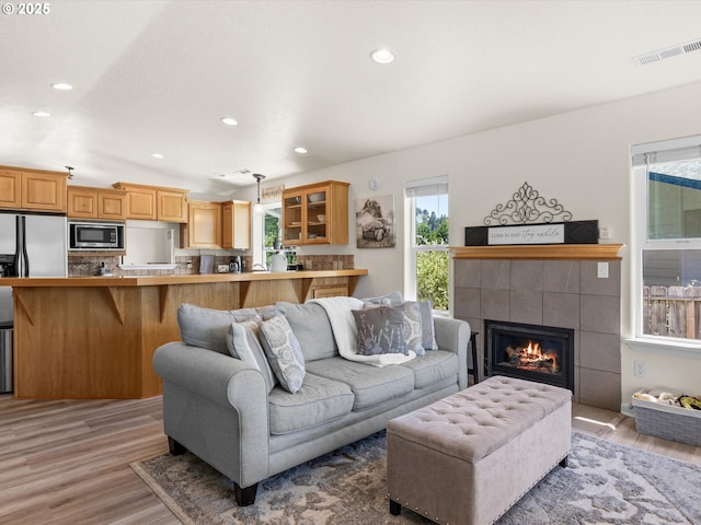 6759 Jasmine Ct, Brookings, OR 97415 - living room with a tiled fireplace, light wood-style floors, visible vents, and recessed lighting