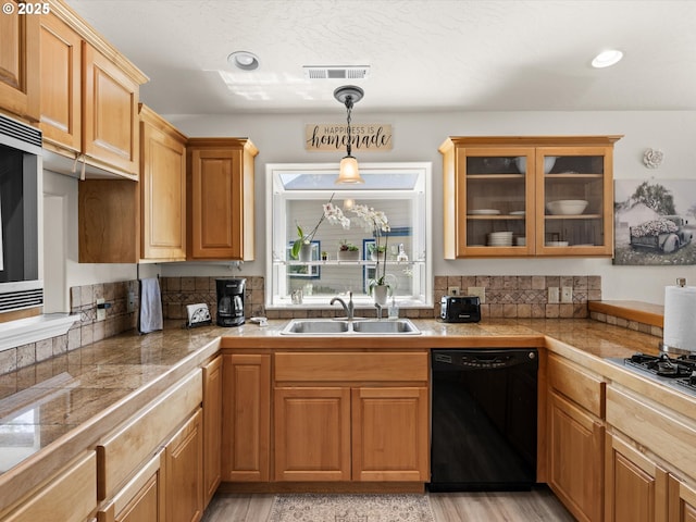 6759 Jasmine Ct, Brookings, OR 97415 - kitchen featuring glass insert cabinets, black dishwasher, hanging light fixtures, visible vents, and a sink