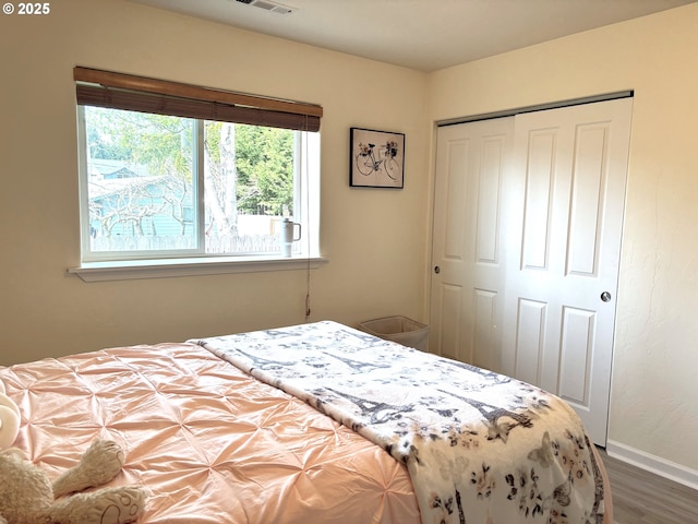 6759 Jasmine Ct, Brookings, OR 97415 - bedroom featuring a closet, visible vents, wood finished floors, and baseboards