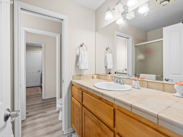 6759 Jasmine Ct, Brookings, OR 97415 - full bathroom featuring baseboards, toilet, a shower stall, vanity, and wood finished floors