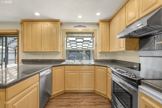 14428 NE Failing St, Portland, OR 97230 - kitchen with under cabinet range hood, appliances with stainless steel finishes, healthy amount of natural light, wood finished floors, and recessed lighting