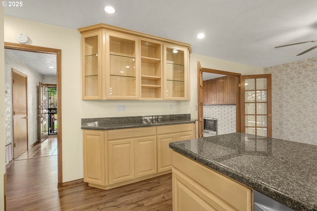 14428 NE Failing St, Portland, OR 97230 - kitchen featuring wood finished floors, ceiling fan, wallpapered walls, glass insert cabinets, and recessed lighting