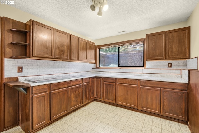 14428 NE Failing St, Portland, OR 97230 - kitchen featuring open shelves, light countertops, light floors, backsplash, and a textured ceiling