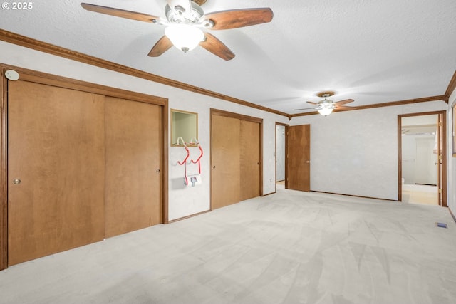 14428 NE Failing St, Portland, OR 97230 - unfurnished bedroom featuring multiple closets, light colored carpet, a textured ceiling, a ceiling fan, and crown molding
