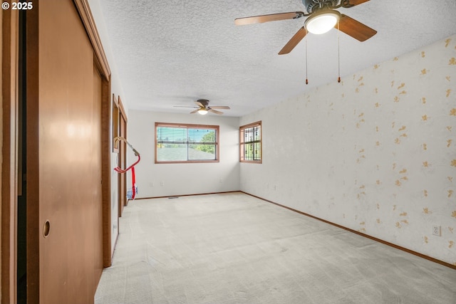 14428 NE Failing St, Portland, OR 97230 - spare room with a textured ceiling, ceiling fan, light carpet, and wallpapered walls