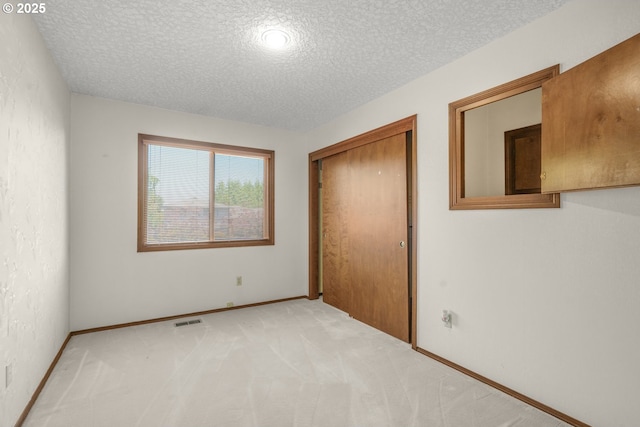 14428 NE Failing St, Portland, OR 97230 - unfurnished bedroom featuring a textured ceiling, a closet, and light carpet