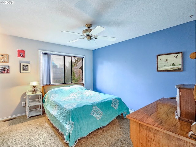 carpeted bedroom with baseboards, ceiling fan, visible vents, and a textured ceiling