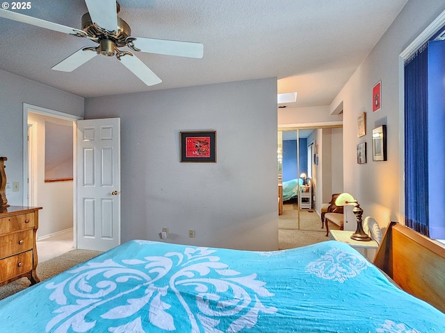 carpeted bedroom featuring a textured ceiling, a ceiling fan, and a closet