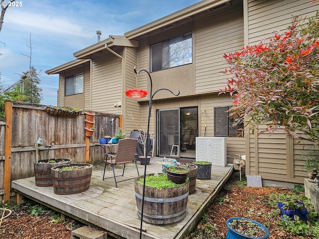 rear view of property with fence and a deck