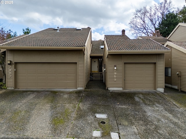 view of front of house featuring a garage and a tiled roof