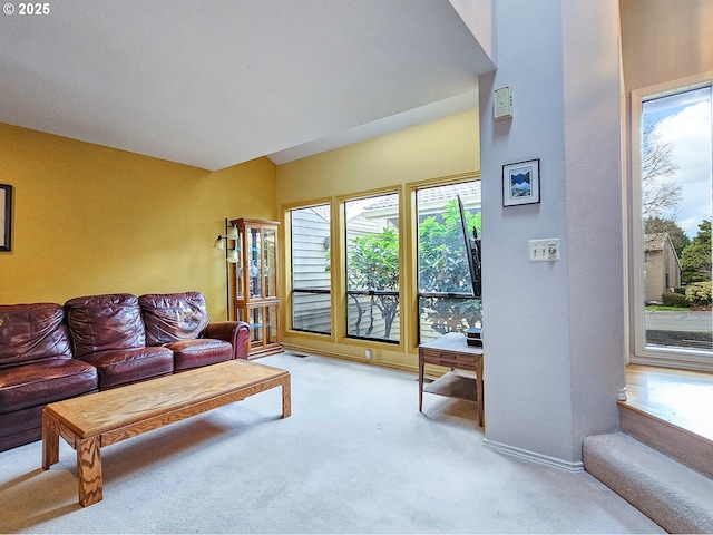 carpeted living area featuring baseboards