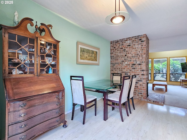 dining area with baseboards and wood finished floors