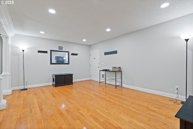 interior space featuring recessed lighting, a textured ceiling, light wood-style flooring, and baseboards