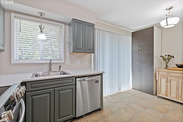 kitchen with stainless steel dishwasher, a sink, gray cabinets, stove, and pendant lighting